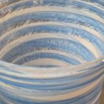 Close-up detail showing the fine white glass cane striations in the swirl pattern of a hand-blown art glass vase